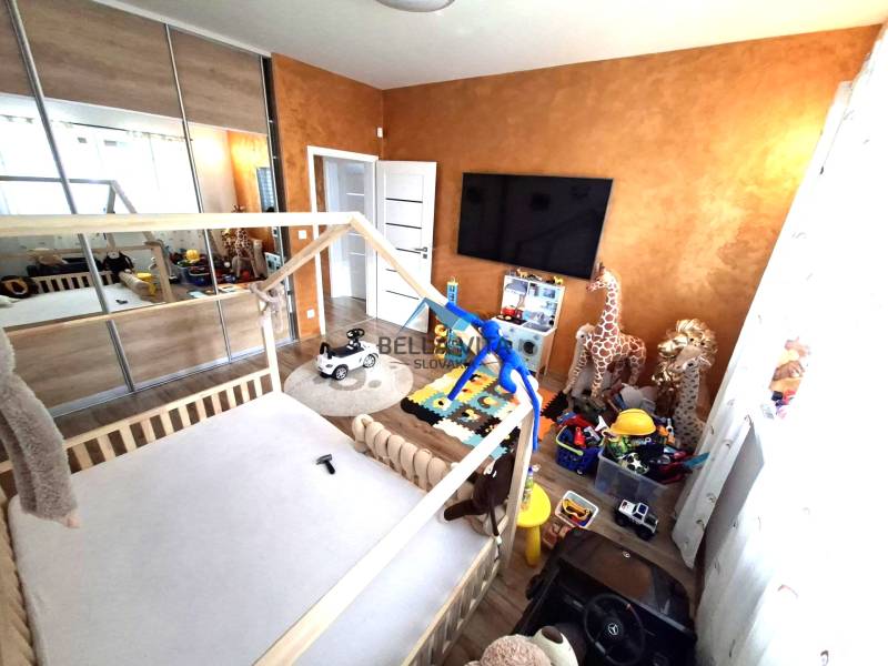 Gyerekszoba családi házban játékokkal, ággyal és szekrényekkel. Fa dekorációjú padló.