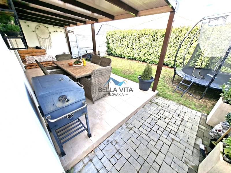 A galántai Mládežnícka utcai családi ház kertje: terasz, trambulin, grill, ülőhely.