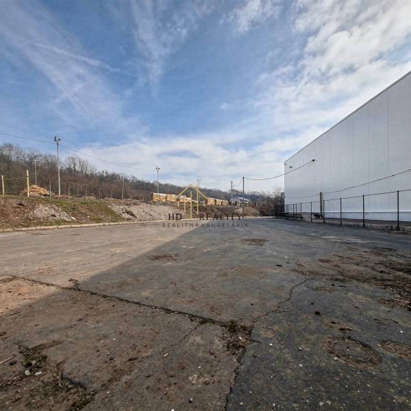 Gyártóhelyiségek Nagykürtösön aszfaltozott területtel és kerítéssel, ipari övezet.