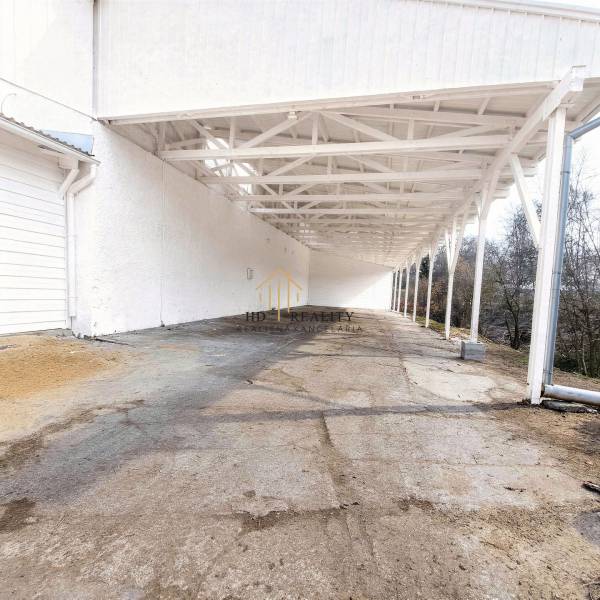 A nagykeresztúri gyártóhelyiségek külső része betonpadlóval és fehér falakkal.