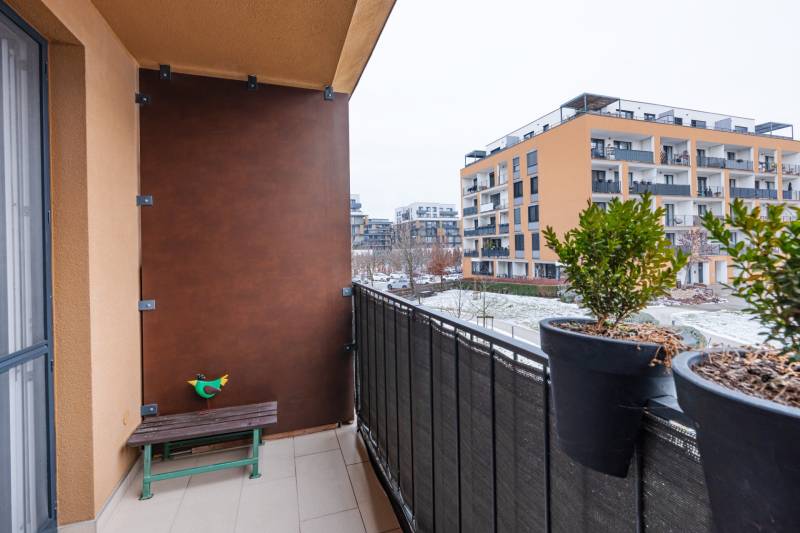 Az egyszobás lakás erkélye a Béžová utcában, Pozsony-Petržalkán, zölddel és padokkal.