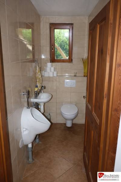 Kis fürdőszoba WC-vel, piszoárral és mosdóval, háromszobás lakásban.