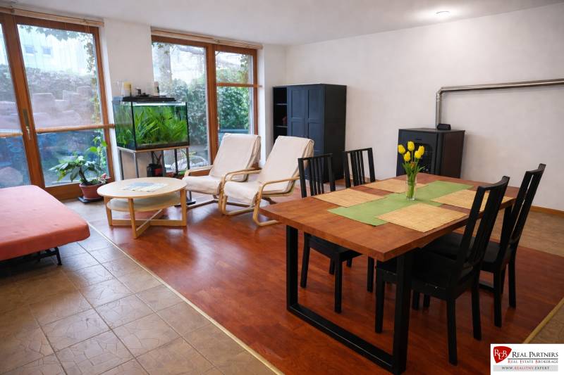 Nappali egy háromszobás lakásban, fa dekoros padlóval, étkezőasztallal és akváriummal.