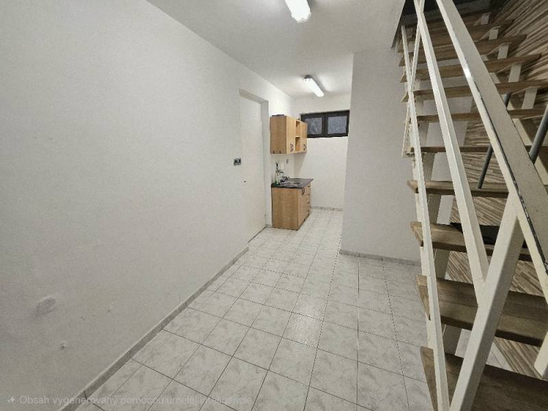 Belső tér fehér falakkal, konyhaszekrénnyel, lépcsővel és fa dekorációjú padlóval.