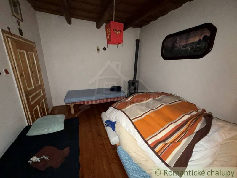 Szoba egy családi házban fa dekorációjú padlóval és egyszerű berendezéssel.