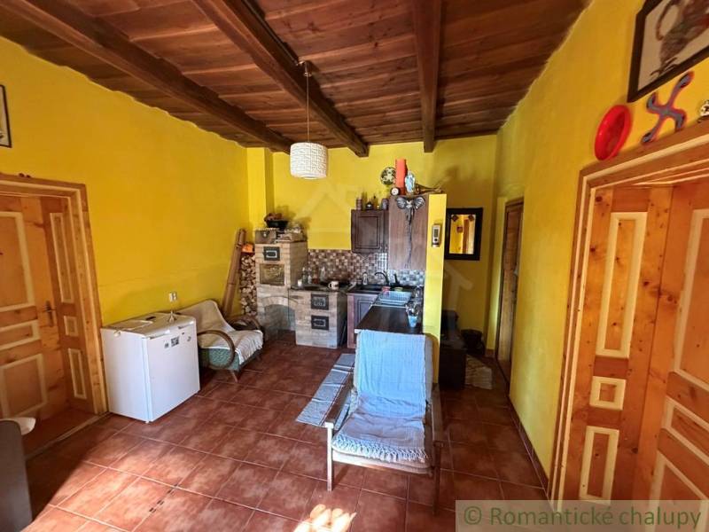 Családi ház belső tere fa mennyezettel és sárga falakkal.