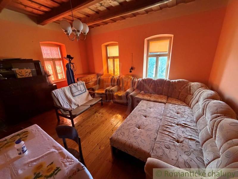 Nappali egy családi házban nagy kanapéval és fa dekorációjú padlóval.