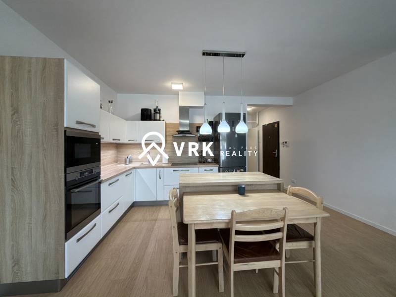 Konyha egy háromszobás lakásban fa dekor padlóval és étkezőasztallal.