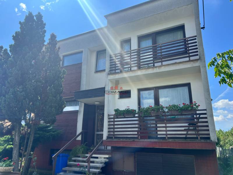 Családi ház Tálova utcában Nagyőrvisen, két erkéllyel, fákkal és garázzsal.