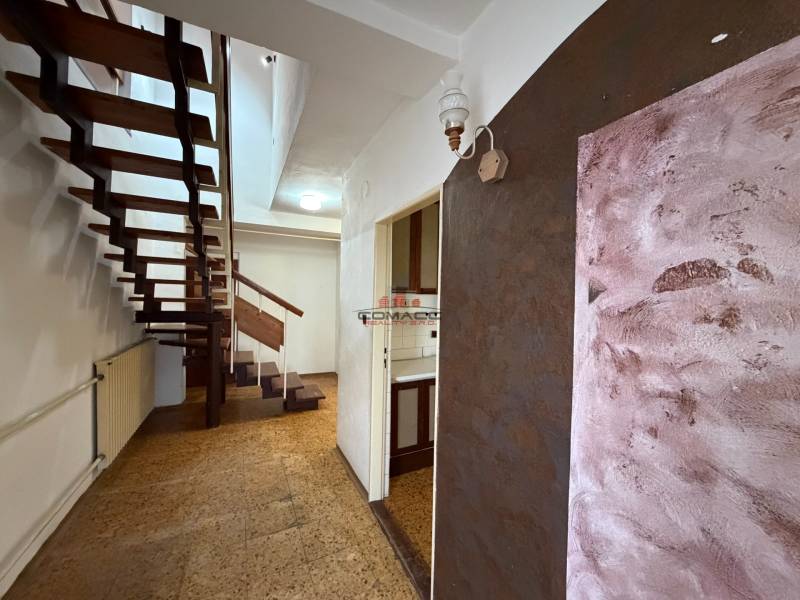 Folyosó nyitott lépcsőkkel egy családi házban, fa dekorációjú padlóval.