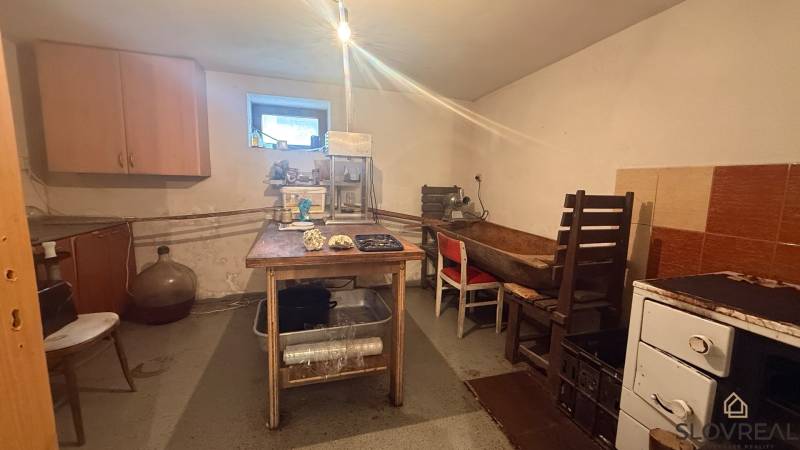 Családi ház konyhája egyszerű bútorokkal és élelmiszer-feldolgozó berendezésekkel.