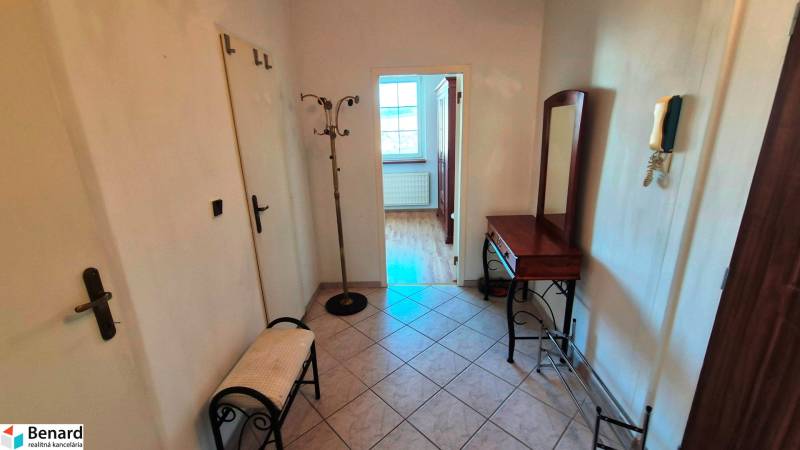 Előszoba egy kétszobás lakásban csempével, tükörrel és páfránnyal.