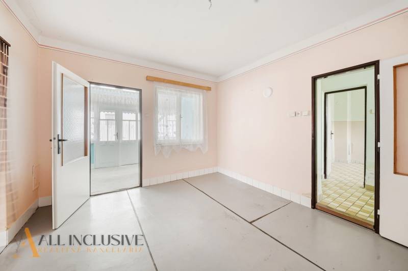 Családi ház belső tere fehér falakkal és üvegezett ajtókkal fa dekoráció nélkül.