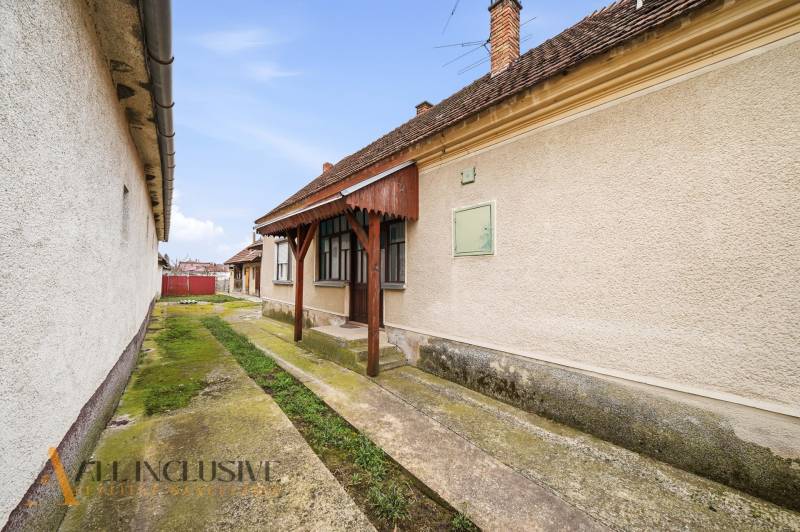 Családi ház Topoľníkyben karbantartott homlokzattal, verandával és betonozott járdával.