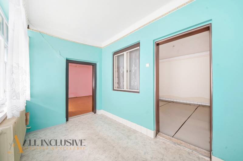 Szoba egy családi házban színes falakkal, laminált padlóval és nagy ablakkal.