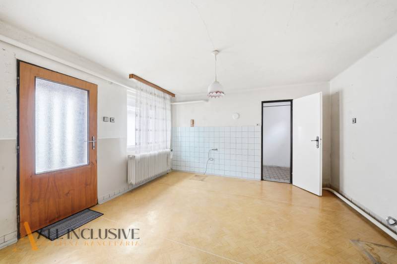 Családi ház belső tere fa mintázatú padlóval és fehér falakkal.