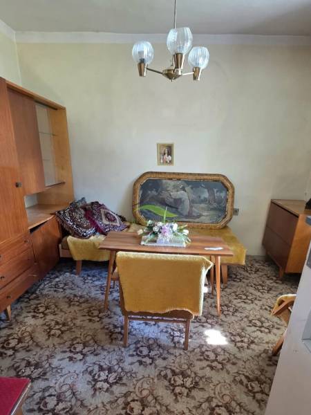 A családi ház ebédlője szőnyegpadlóval, bútorokkal és függő csillárral rendelkezik.