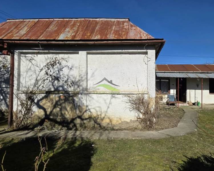 Családi ház Pavlovce nad Uhom-ban udvarral, rozsdásodó bádogtetővel.