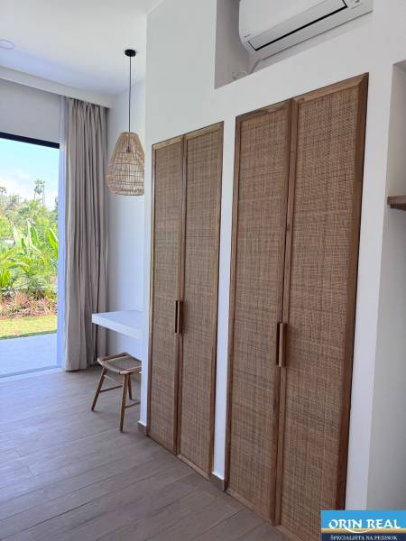 Családi ház belső tere fa dekorációjú padlóval és rattan elemekkel.