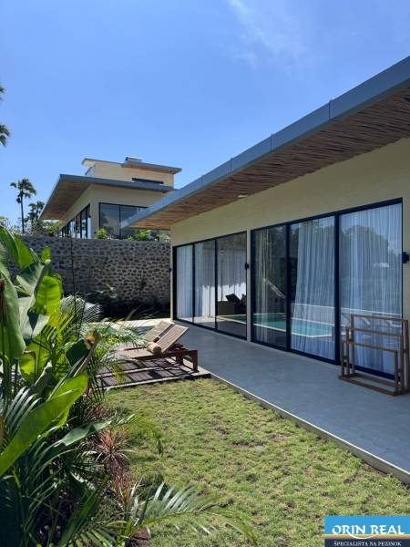 Amedei családi ház kertje üveggel és nyugágyakkal a teraszon.