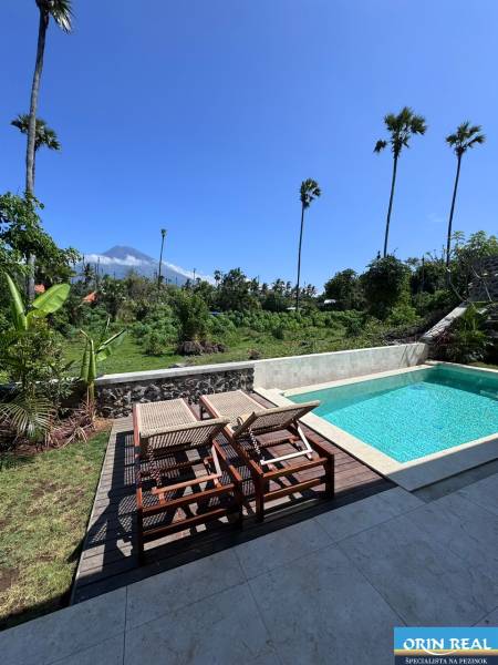 Napozóágyak és napozóágyak kilátással a zöldre az Amed utcában, Amed, egy családi ház mellett.