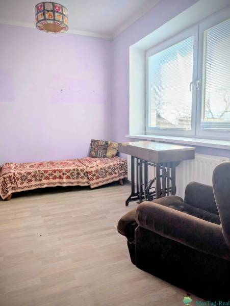 Szoba családi házban kinyitható kanapéval és fotellel, fa dekoros padlóval.