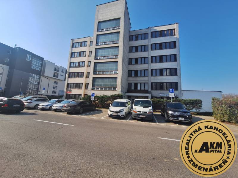 Irodaház a Tulská utcában, Zvolen városában, parkolóval és parkoló autókkal.