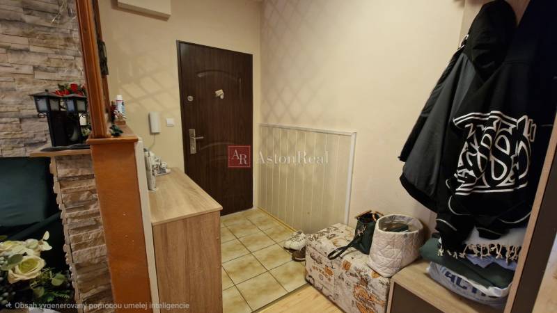 Előszoba egy háromszobás lakásban kőburkolattal és tárolóhelyekkel.