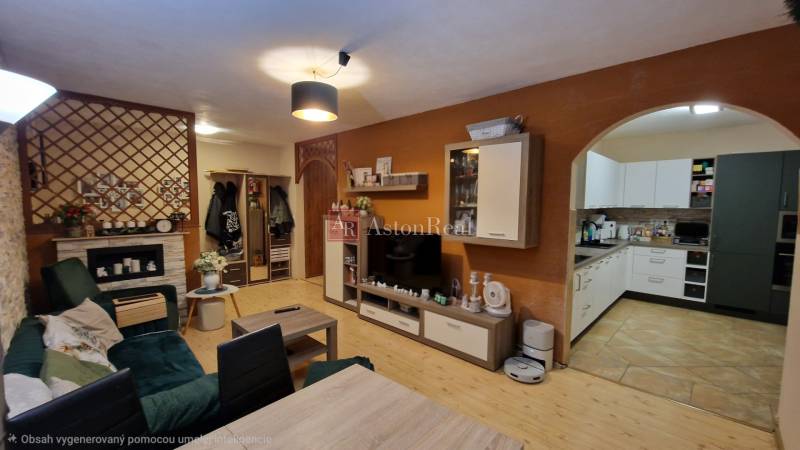 Nappali egy háromszobás lakásban fa dekorációjú padlóval és nyitott konyhával.