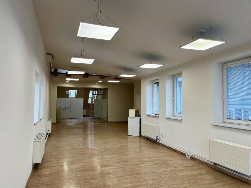 Irodák fa dekor padlóval, függesztett lámpákkal és üvegajtókkal.