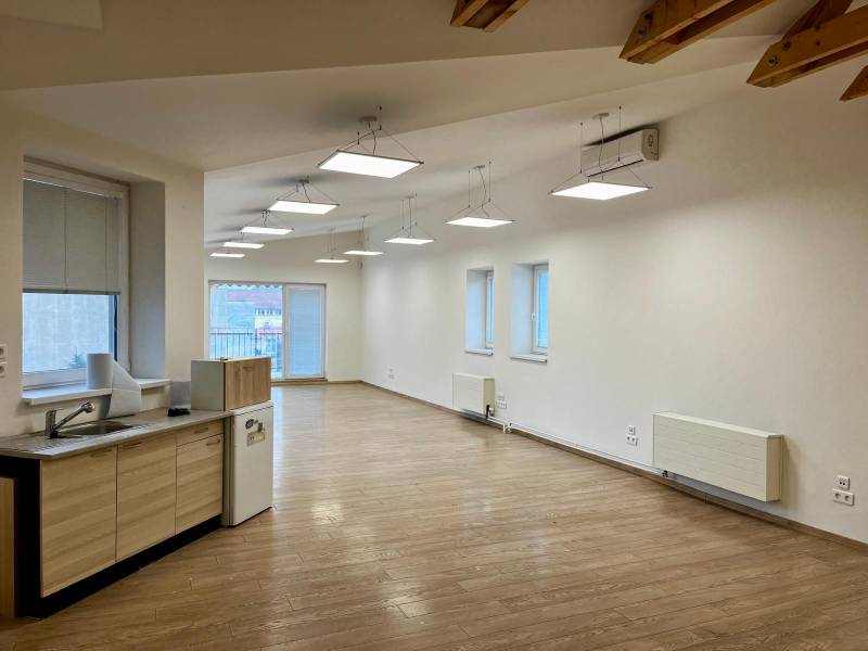 Irodák fa dekor padlóval és konyhasarokkal, mennyezeti világítással.