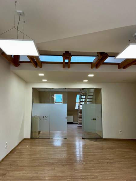 Iroda belső tér fa dekor padlóval és üvegajtókkal.