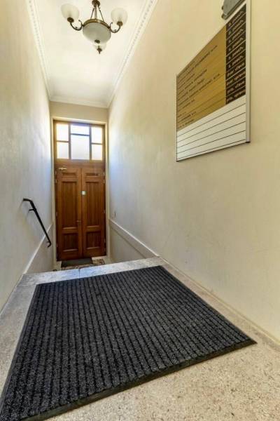 Keskeny lépcsőház létrával és lámpával vezet a faajtóhoz. Irodák.