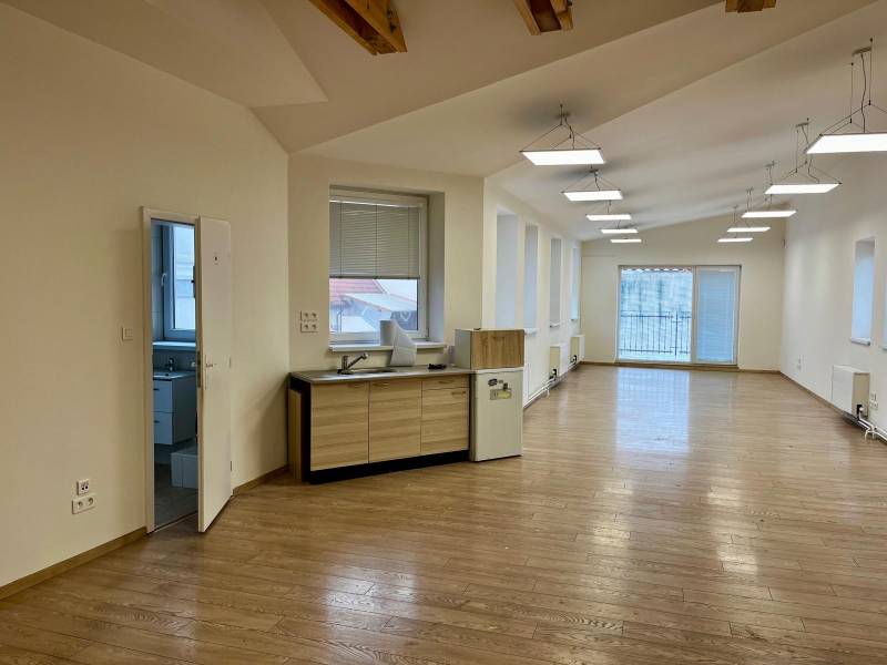 Irodák fa dekor padlóval, nagy ablakokkal és konyhasarokkal.