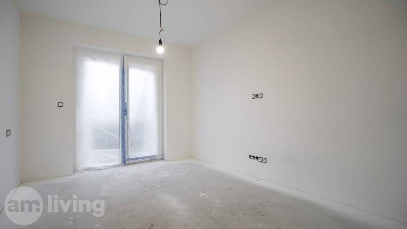 Egy üres szoba egy családi házban függő lámpával és zárt teraszajtóval.