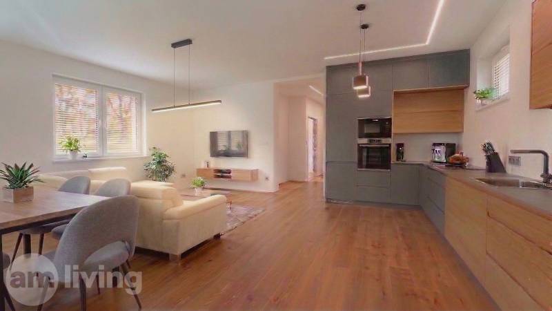 Nappali egy családi házban, kanapéval és fa dekorációjú padlóval.