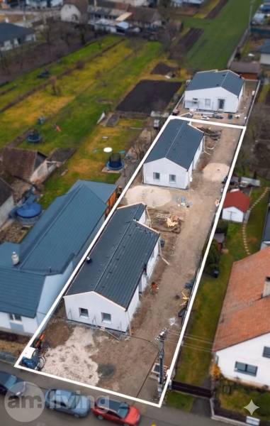 Családi házak építése Borcsicén, kertekkel és szomszédos házakkal körülvéve.