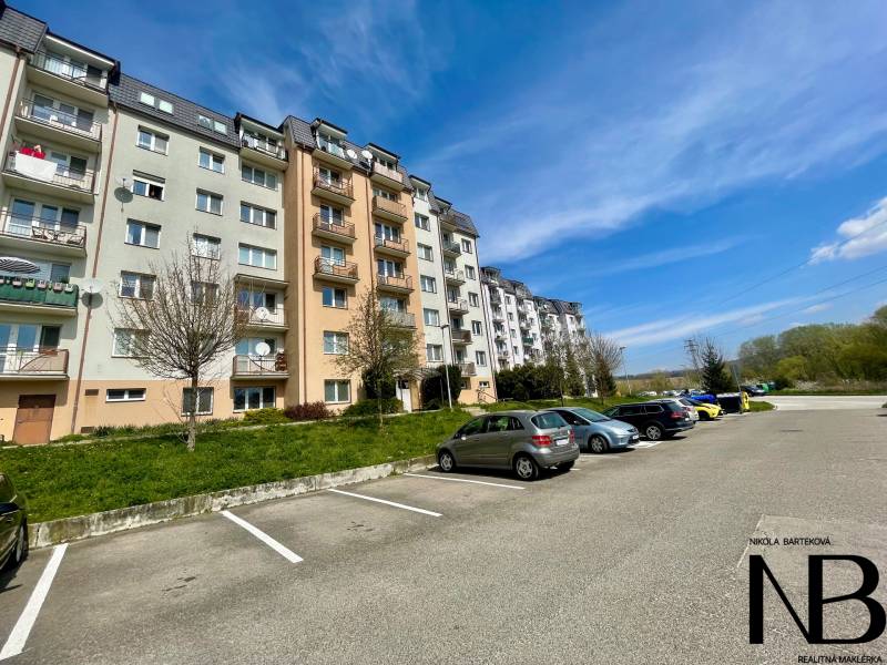 Konténerház a Východná utcán, parkoló, fák, 2 szobás lakás, kék ég, autó.