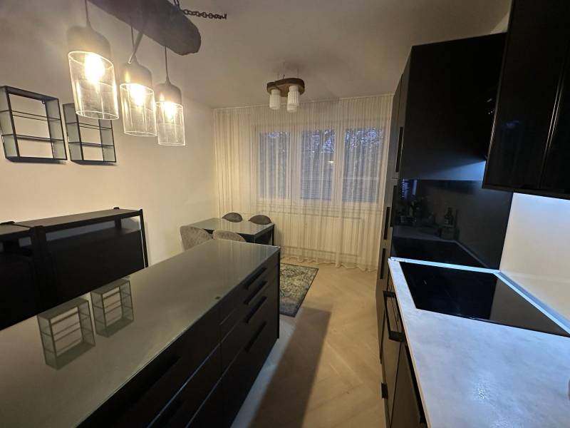 Konyha egy kétszobás lakásban üveglámpákkal és fa dekorációjú padlóval.