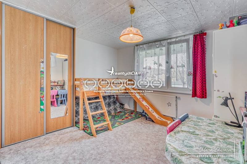 Gyerekszoba emeletes ággyal, szekrényekkel és színes székekkel egy 4 szobás lakásban.