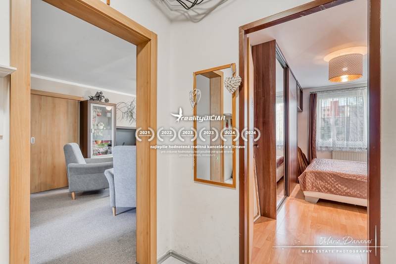 Egy 4 szobás lakás belső tere fa dekor padlóval, bútorokkal és tükörrel.