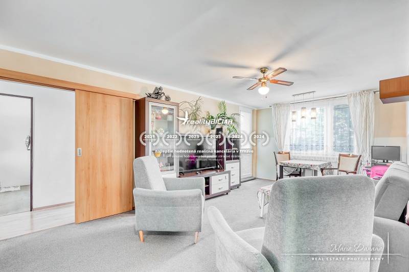 Világos nappali kanapékkal egy 4 szobás lakásban, fa mintázatú padlóval.