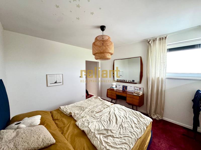 Hálószoba családi házban ággyal, tükörrel és piros szőnyeggel a padlón.