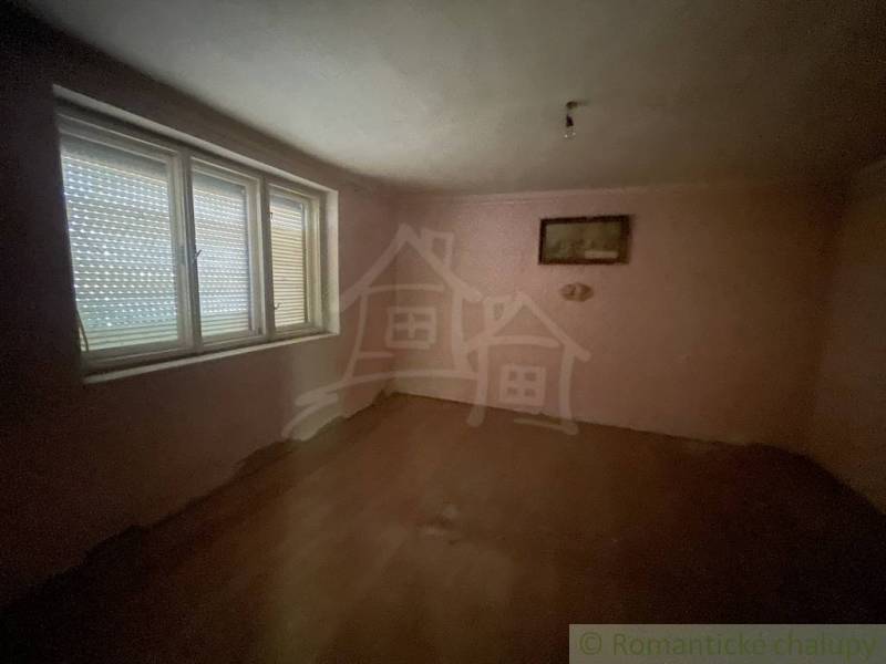 Egy családi ház üres szobája fa dekorációs padlóval és nagy ablakkal.