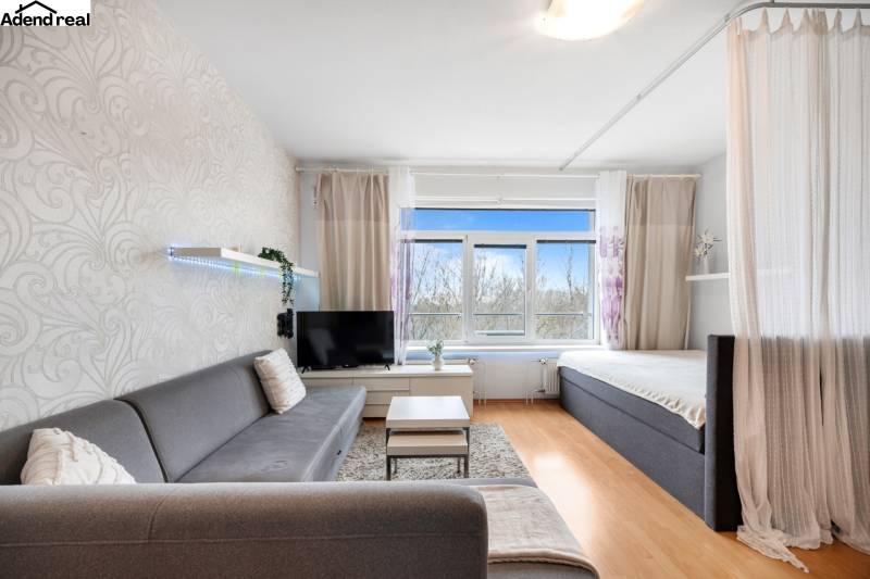 Nappali kanapéval, függönnyel és televízióval, fa dekorációjú padlóval.