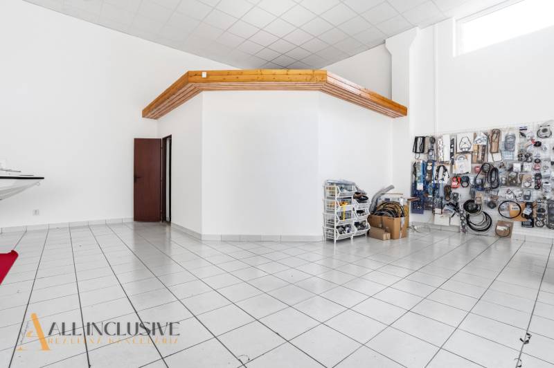 Kereskedelmi helyiségek fehér falakkal és kerámia padlóval. Része a tárolt áru.