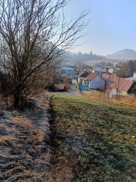 Táj Szkáblányban lakótelkekkel, házakkal és fákkal a háttérben.