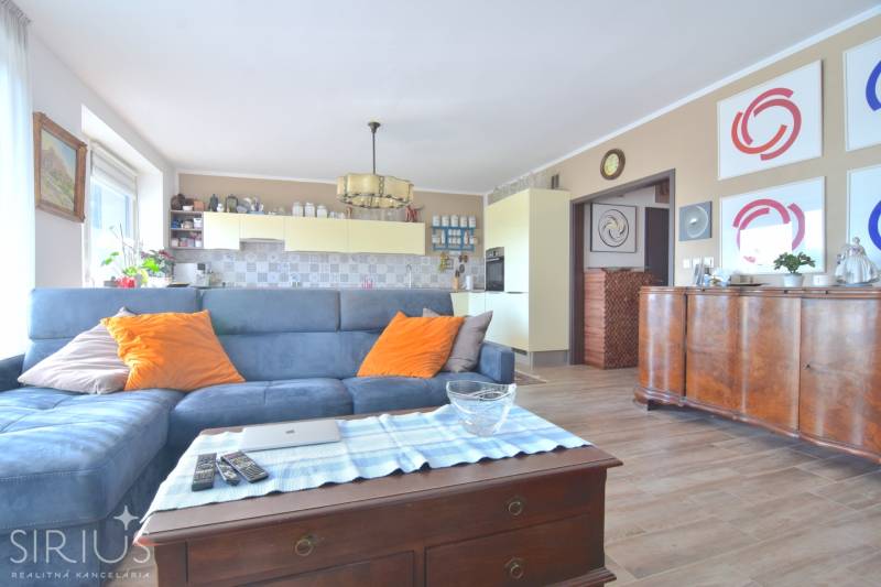 Nappali kék kanapéval, fa dekoros padló, 3 szobás lakás.