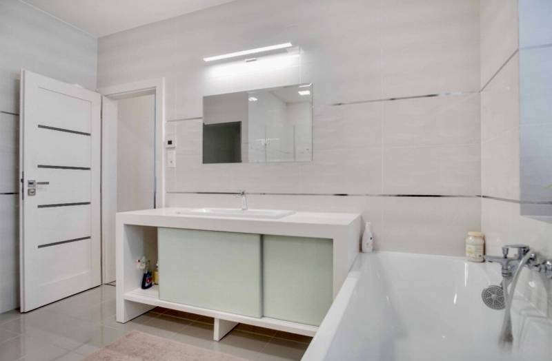 Fürdőszoba káddal és tükörrel egy háromszobás lakásban.