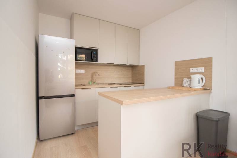 Konyha egy 3 szobás lakásban fa dekor padlóval és modern készülékekkel.